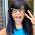 Jess Wade smiling and winking at the camera, making the peace sign with her left hand.